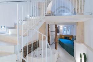 a white spiral staircase in a room with a couch at Corte dei Condò Luxury Rooms in Lecce
