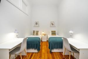 two beds in a room with a table and chairs at Modern Nomad Hub Stylish Spaces for Remote Living in Lisbon