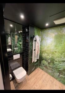 La salle de bains est pourvue de toilettes et d'une douche aux murs verts. dans l'établissement Suite in Tempelhof, à Berlin