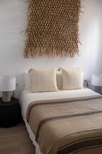 a bedroom with a bed with two lamps and a wall at Exquisito apartamento en el Centro San Francisco 2 in Gandía