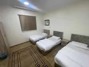 Pokój z 2 łóżkami i tablicą na ścianie w obiekcie شقق الفتح الخاصة Al-Fateh Private Apartments w Medynie