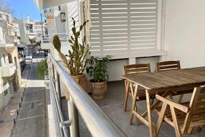 einen Holztisch und Stühle auf dem Balkon in der Unterkunft 3-bedroom central, spacious and bright apartment. in Iraklio