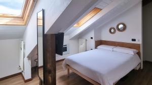 ein Schlafzimmer mit einem Bett und einem TV im Dachgeschoss in der Unterkunft B&B Casa Monella in Val di Sole in Monclassico