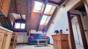 ein Wohnzimmer mit einem blauen Sofa und einigen Fenstern in der Unterkunft B&B Casa Monella in Val di Sole in Monclassico