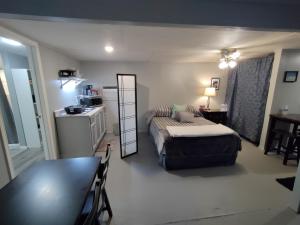 a bedroom with a bed and a table and a kitchen at Make Yourself at Home in Austin