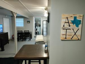 a living room with a table and a painting on the wall at Make Yourself at Home in Austin