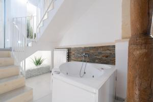a bathroom with a white tub and a staircase at Corte dei Condò Luxury Rooms in Lecce