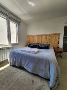 a bedroom with a large bed with two towels on it at Inmejorable ubicación y diseño! in San Carlos de Bariloche