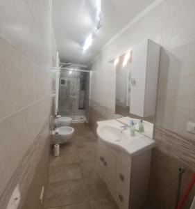 uma casa de banho branca com um lavatório e um WC em Trilocale nel centro di Sampierdarena em Gênova