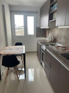 a kitchen with a counter and a table and chairs at Inmejorable ubicación y diseño! in San Carlos de Bariloche