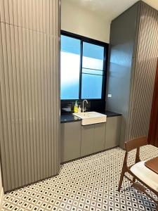 ein Bad mit einem Waschbecken und einem Fenster in der Unterkunft House40 - MRT Ratchadaphisek in Bangkok