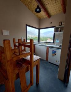 Una cocina con una mesa y sillas en una habitación. en Cabañas Riviera, en Huacalera