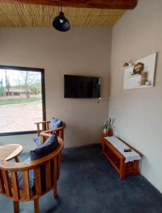 a living room with two chairs and a flat screen tv at CABAÑAS RIVIERA in Huacalera