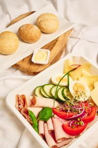 a plate of food with meat and vegetables and bread at Hostel L44 in Nowy Targ