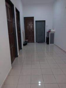 pasillo con 2 puertas y suelo de baldosa blanca en Panorama Indah Homestay, en Sungai Besar
