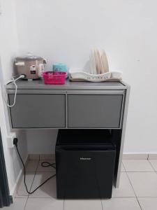 einen schwarzen Schreibtisch mit einem Gerät und einer Box in der Unterkunft Panorama Indah Homestay in Sungai Besar