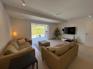 a living room with two couches and a flat screen tv at Villa Les Palmiers St. Maxime in Sainte-Maxime