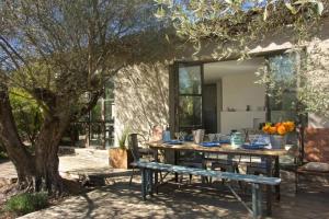 a wooden table and bench under a tree at La Matina Family Haven with Olive Garden Oasis in Lauris