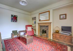 uma sala de estar com uma cadeira vermelha e uma lareira em Tusker House em Wells-next-the-Sea