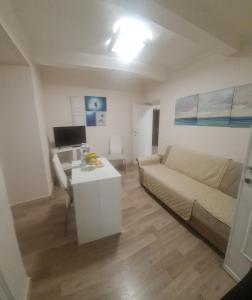 uma sala de estar com um sofá e uma mesa em Trilocale nel centro di Sampierdarena em Gênova