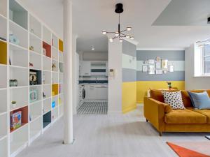 sala de estar con sofá amarillo y cocina en Quirky City Centre Apartment Free parking Pass the Keys, en Mánchester