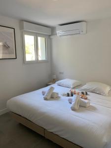 a large white bed with two stuffed animals on it at Appartement Marina di Fiori by Intendance Excellency in Porto-Vecchio