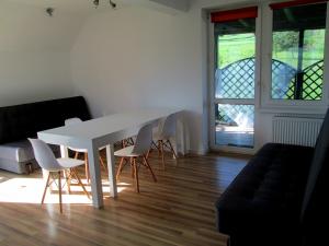 una mesa y sillas blancas en una habitación con ventana en W Rajbrocie u Ewusi, en Rajbrot