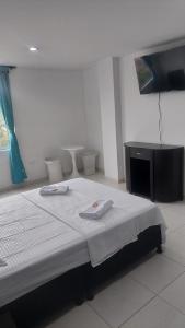 ポパヤンにあるEDIFICIO MALU REAL habitaciones y apartaestudios sin cocinaのベッドルーム1室(ベッド1台、タオル2枚付)