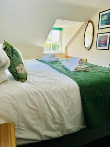 赫克瑟姆的住宿－The Boatside Inn - North Tyne - 2 Bedroom Cottage，一间卧室配有两张带绿色和白色床单的床