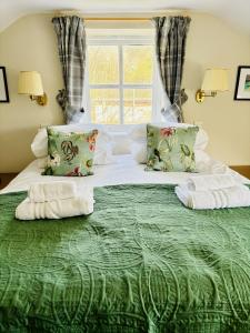 赫克瑟姆的住宿－The Boatside Inn - North Tyne - 2 Bedroom Cottage，一张绿色大床,上面有两条毛巾