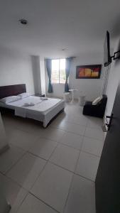 a white bedroom with a bed and a window at EDIFICIO MALU REAL habitaciones y apartaestudios sin cocina in Popayan