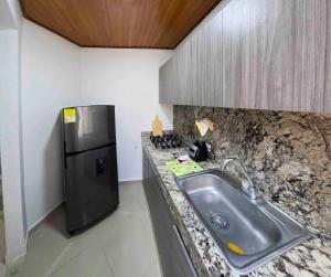 een keuken met een wastafel en een koelkast bij Casa rodadero in Santa Marta