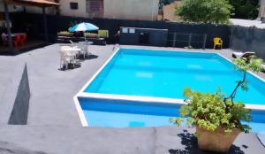 a swimming pool in a backyard with a blue pool at Ambassador Hotel in Foz do Iguaçu