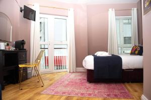 1 dormitorio con cama, escritorio y ventana en The Galway Rooms, en Galway