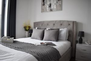 a bedroom with a bed with a book on it at Stunning 2 bed with balcony in Brentwood Essex in Brentwood