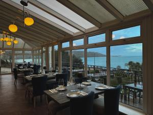 a restaurant with tables and chairs and a view of the ocean at Nomi Rooms & Restaurant in Bangor