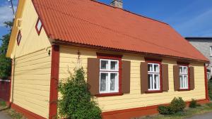a yellow and red house with a red roof at Romantic Seaside House in Pärnu