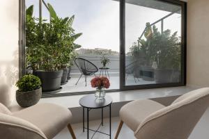 una habitación con sillas y macetas en un balcón en Regal Hotel Mitropoleos, en Atenas