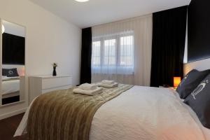 a bedroom with a bed with two towels on it at The Queen Luxury apartments - Villa Giorgia in Dudelange