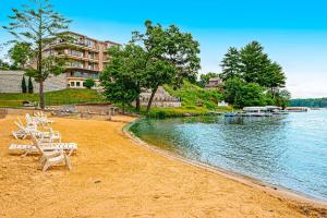 uma praia com cadeiras e um edifício e água em Lake Front Chillin em Wisconsin Dells