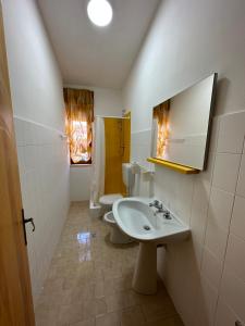 La salle de bains est pourvue d'un lavabo, de toilettes et d'un miroir. dans l'établissement La Limonaia, à Cipollina