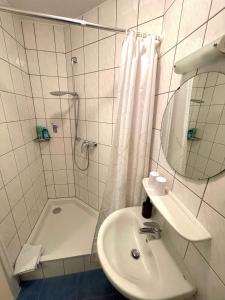 a white bathroom with a shower and a sink at Fewo TRINA in Bernkastel-Kues