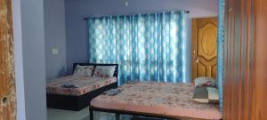um quarto com 2 camas individuais e uma janela em Nestle Beachfront Murudeshwar em Māvalli