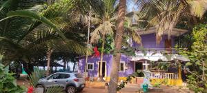 MāvalliNestle Sahayadri Beachfront Murudeshwar的一座紫色的房子,前面有一辆汽车