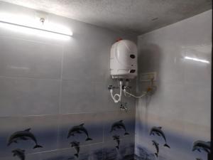 a bathroom with a shower with dolphins on the wall at Nestle Beachfront Murudeshwar in Māvalli