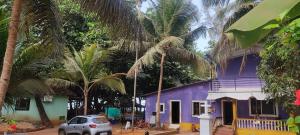 a purple building with palm trees in front of it at Nestle Beachfront Murudeshwar in Māvalli