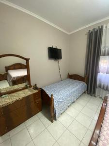 een slaapkamer met 2 bedden en een flatscreen-tv bij Vila Besim in Berat