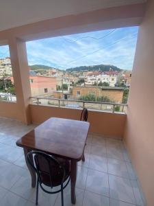 een tafel en een stoel in een kamer met een groot raam bij Vila Besim in Berat
