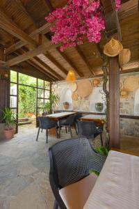 een patio met tafels en stoelen en roze bloemen bij VILLA SOL in Sunny Beach