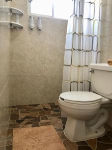 a bathroom with a toilet and a shower at Casa Múkara del Puerto in Veracruz
